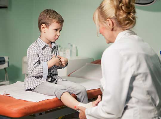 nurse practitioner cares for young boy with sprained ankle