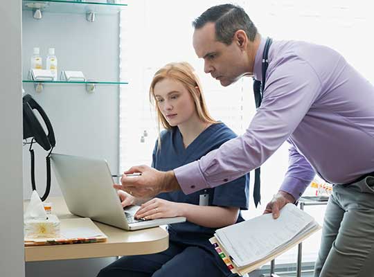 nurse studying for online msn program on laptop