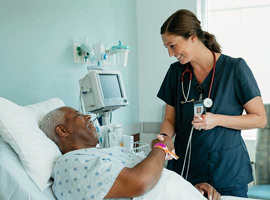 registered nurse with her rn to bsn degree shakes hands with a patient