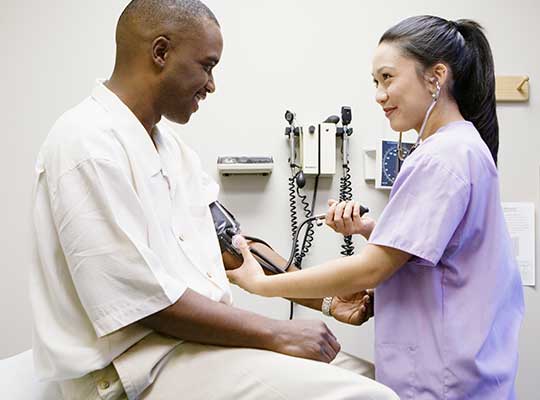registered nurses takes blood pressure of patient